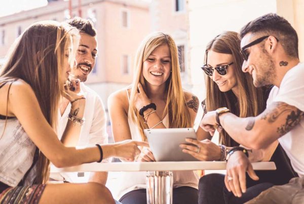 comunicazione-integrata-ragazzi-che-discutono-di-un-brand-e-guardano-un-tablet